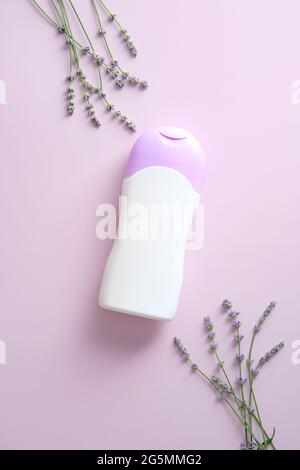 Bouteille de produit naturel de soin de la peau mockup avec lavande sur fond violet. Flat lay, vue de dessus. Conception de contenant de produit de beauté à base de plantes. Banque D'Images