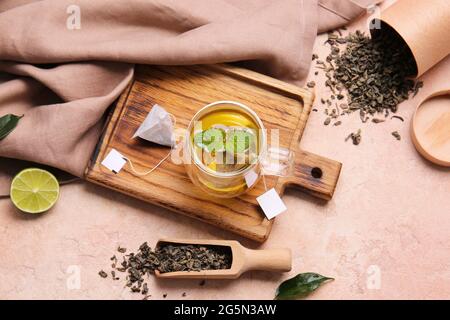 Planche en bois avec tasse de thé vert savoureux sur fond de couleur Banque D'Images