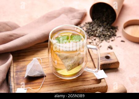 Planche en bois avec tasse de thé vert savoureux sur fond de couleur Banque D'Images