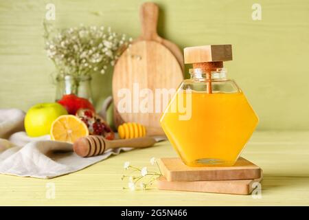 Pot de miel et de fruits sur fond de couleur, gros plan Banque D'Images