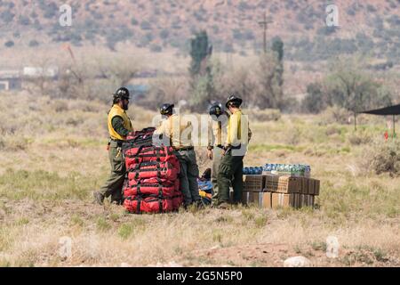 Un équipage empile des fournitures et des liquides d'hydratation pour les faire passer par hélicoptère aux pompiers qui combattent un incendie de forêt dans les montagnes de la Sal en Utah. Banque D'Images