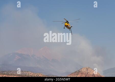 Un hélicoptère Sikorsky S-61 de lutte contre les incendies retourne à la surface après avoir laissé tomber de l'eau sur un feu de forêt dans les montagnes de la Sal dans l'Utah. Banque D'Images