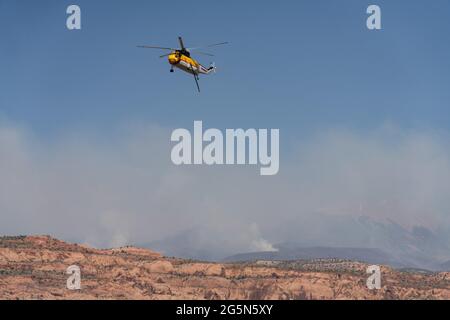 Un hélicoptère Sikorsky S-61 de lutte contre les incendies retourne à la surface après avoir laissé tomber de l'eau sur un feu de forêt dans les montagnes de la Sal dans l'Utah. Banque D'Images