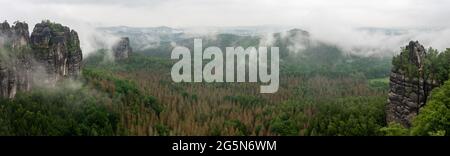 Vue panoramique sur les montagnes dans la brume matinale. Schrammsteine - groupe de roches sont un long, strung-out, très déchiquetés dans la montagne de grès d'Elbe Banque D'Images