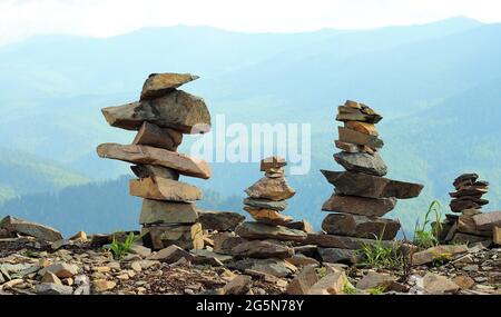 Plusieurs petites pyramides en pierre au sommet de la montagne surplombant la taïga vallonnée. Mont Kokuya, Altaï, Sibérie, Russie. Banque D'Images