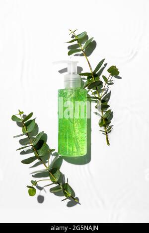 Bouteille de produit cosmétique et branches d'eucalyptus sur fond blanc Banque D'Images