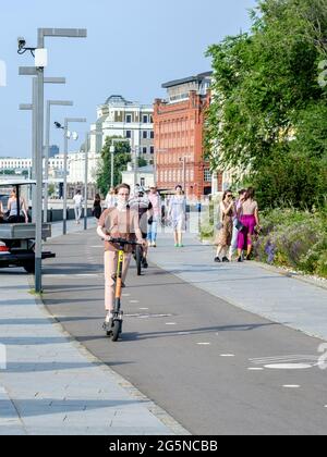 Moscou. Russie. 26 juin 2021. Une jeune fille à bord d'un scooter électrique fait une piste cyclable le long du remblai de la ville par une belle journée d'été. Moderne, zéro Banque D'Images