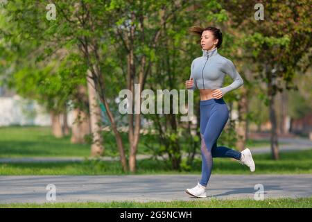 Photo of a Woman Running in Park in Early Morning. Attractive