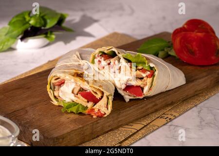 Shawarma ou burrito maison ou rouleau de poulet avec légumes et sauce Banque D'Images