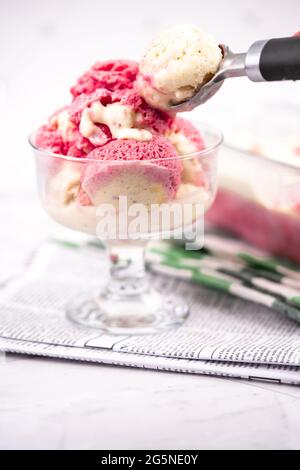 Yaourt glacé à la fraise dans un bol en verre, boules de crème glacée, contenant avec sundae faits maison Banque D'Images