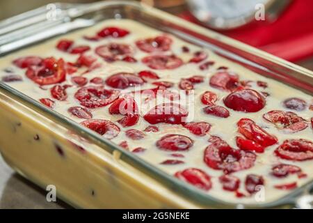 Pâte prête à l'emploi avec cerises dans le moule à tarte aux cerises, clafoutis. Recette étape par étape. Banque D'Images