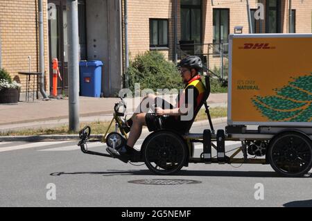 Kastrup/ Danemark. 28 juin 2021, DHL allemand cycliste livreur homme en action à Kastrup il conduit vélo à la livraison paquet. (Photo..Francis Joseph D. Banque D'Images