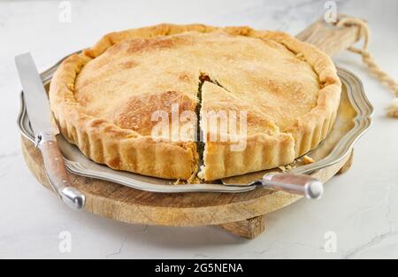 Prêt de tarte suisse avec verger, riz, oignons et pignons sur un support en bois sur marbre blanc Banque D'Images