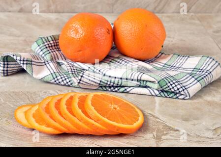 Des tranches d'oranges fraîches mûres sur un comptoir de cuisine Banque D'Images