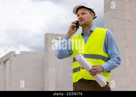 superviseur de l'ingénieur en construction travaillant sur le chantier. parler au téléphone Banque D'Images