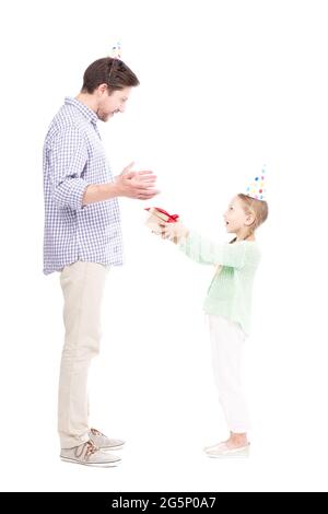 Vue latérale verticale sur toute la longueur photo d'une jolie fille caucasienne donnant une boîte cadeau à son père, fond blanc Banque D'Images