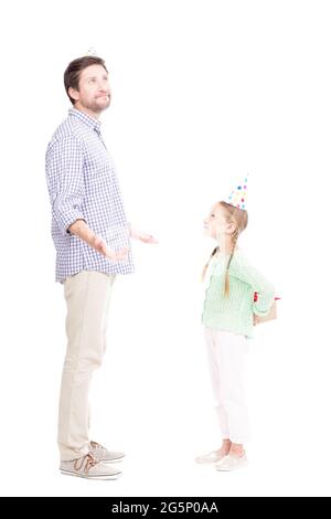 Vue latérale verticale sur toute la longueur photo d'une jolie fille caucasienne donnant une boîte cadeau à son père, fond blanc Banque D'Images