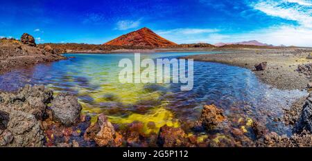 Rouge montagne et vert flaque près de la côte de mer dans l'île des Canaries, Lanzarote.Espagne plages.Impressionnante et pittoresque nature volcanique unique à Timanfaya Banque D'Images