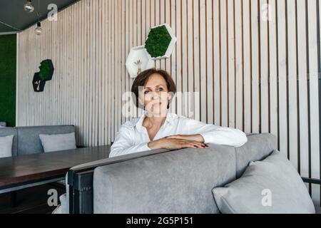 Femme d'affaires senior se reposer dans un café moderne. Banque D'Images