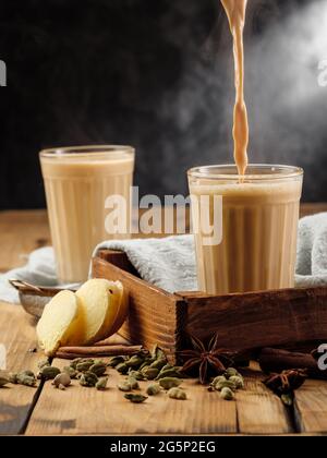 Deux verres à facettes sur une table en bois avec le traditionnel chai indien de boisson masala. Copier l'espace. Banque D'Images