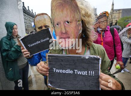 Londres, Royaume-Uni. 21 juin 2021. Des manifestants portant des masques Boris Johnson, Matt Hancock et Bill Gates tiennent des plaques pendant la manifestation.des manifestants anti-verrouillage et anti-vaccination ont organisé une manifestation contre l'extension du confinement, les masques et les passeports de vaccination. Crédit : Martin Pope/SOPA Images/ZUMA Wire/Alay Live News Banque D'Images