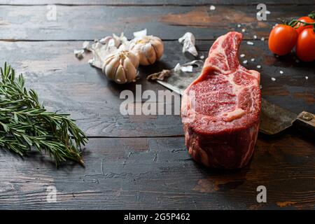 Bœuf cru Dallas steak, qui se trouve sur le couteau de coupe. Viande de bœuf crue préparée pour la cuisson des steaks. À côté des ingrédients pour la cuisson des steaks, épices a Banque D'Images