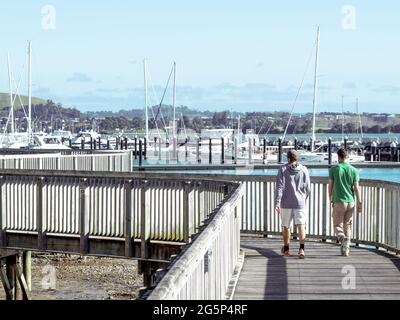 AUCKLAND, NOUVELLE-ZÉLANDE - 21 juin 2021 : personnes marchant à Bucklands Beach jusqu'à Half Moon Bay Marina sentier en bois. Auckland, Nouvelle-Zélande - 21 juin 2021 Banque D'Images