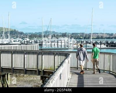 AUCKLAND, NOUVELLE-ZÉLANDE - 21 juin 2021 : personnes marchant à Bucklands Beach jusqu'à Half Moon Bay Marina sentier en bois. Auckland, Nouvelle-Zélande - 21 juin 2021 Banque D'Images