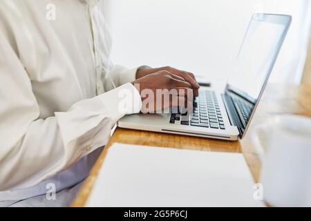 L'homme d'affaires écrit avec le système tactile sur le PC portable dans le bureau ou dans le bureau à domicile Banque D'Images