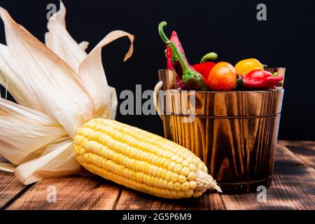 Saveur mexicaine. Légumes mexicains. Piments et tomates cerises dans un seau en bois. Corn Banque D'Images