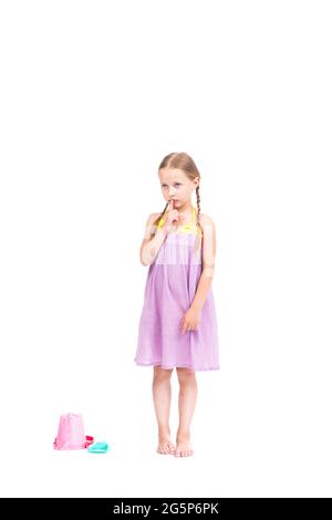 Vertical pleine longueur studio portrait de mignon pensif caucasien fille portant l'ensemble d'été pensant à quelque chose, fond blanc Banque D'Images