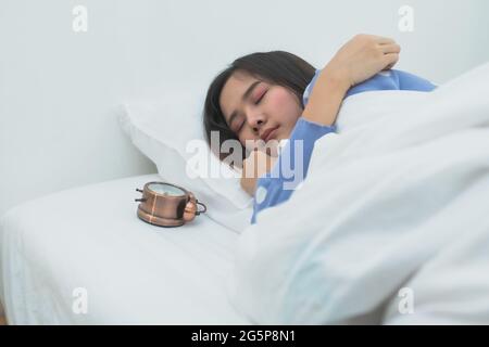 belle femme dormant au lit et se lever tard Banque D'Images