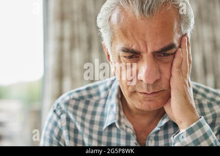 Tête et épaules prise de vue d'un homme senior inquiet à la maison Banque D'Images
