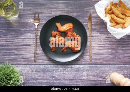 filets de poulet frits sur l'assiette et chips de pommes de terre sur fond de bois Banque D'Images