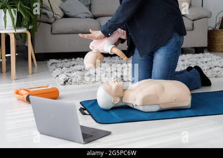 Ambulancier présentant les premiers soins sur mannequin pendant la formation seule dans le salon. L'instructeur montrant la RCP sur la poupée d'entraînement Banque D'Images