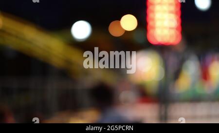 Lumières de bokeh démoussantes faites d'attractions effrayantes tournant dans Luna Park Banque D'Images