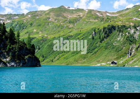 Vue panoramique sur le lac Tappenkar dans les Alpes autrichiennes. Eaux cristallines et montagnes environnantes avec prairies en été. Paysage alpin Banque D'Images