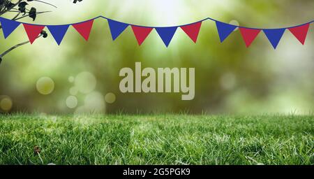 Composition des fanions en rouge et bleu du drapeau américain, sur l'herbe verte et la lumière de bokeh dans le jardin Banque D'Images