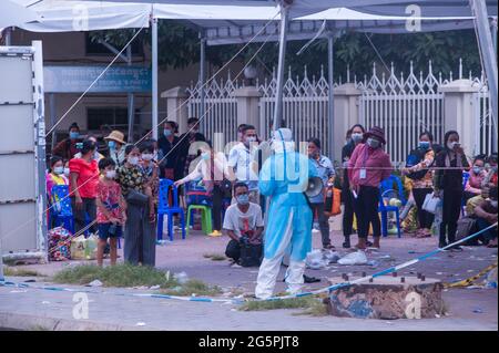 Phnom Penh, Cambodge. Le 29 juin 2021. Depuis 4 mois, Phnom Penh lutte contre une vague de COVID - 19. Un EMT dans l'EPI complet dirige un site de tests de masse. Une mère cambodgienne et ses deux petits garçons ont tous été testés positifs pour le virus et sont ramassés par une ambulance. Credit: Kraig Lieb / Alamy Live News Banque D'Images