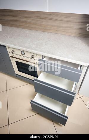 Solution pour placer les ustensiles de cuisine dans une cuisine moderne. Étagères coulissantes à tiroir coulissant horizontales rangement dans une armoire pour ustensiles de cuisine sous porcelaine Banque D'Images
