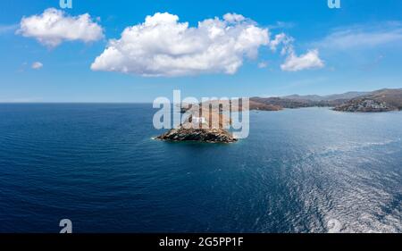 Île de Kea Tzia. Grèce, Cyclades. Drone, vue aérienne du phare et de l'église Agios Nikolaos sur un cap rocheux, ciel bleu et rippé eau de mer Backgrou Banque D'Images