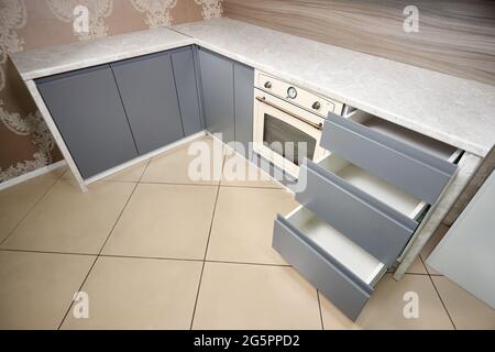 Solution pour placer les ustensiles de cuisine dans une cuisine moderne. Étagères coulissantes à tiroir coulissant horizontales rangement dans une armoire pour ustensiles de cuisine sous porcelaine Banque D'Images
