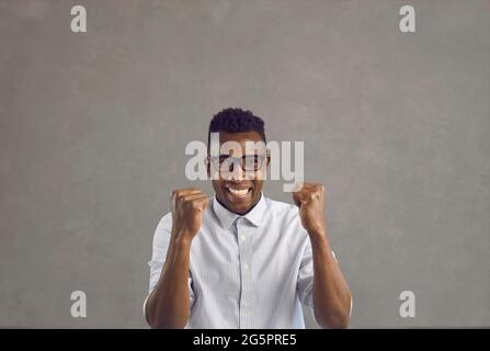 Portrait d'un homme afro-américain surjoyé avec un poing fermé se sentant excité Banque D'Images