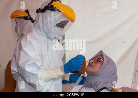 Kendari, Indonésie. 29 juin 2021. Un travailleur de la santé prélève un échantillon d'écouvillonnage d'une femme pour un test COVID-19 à Kendari, Sulawesi du Sud-est, Indonésie, le 29 juin 2021. Les cas de COVID-19 en Indonésie ont augmenté de 20,467 dans les 24 dernières heures, pour atteindre 2,156,465, le nombre de décès ayant augmenté de 463 à 58,024, a déclaré le ministère de la Santé mardi. Crédit : Opas/Xinhua/Alay Live News Banque D'Images