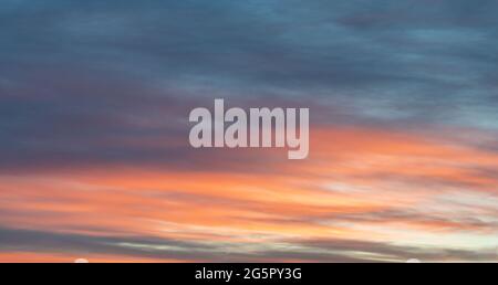 Photo colorée du ciel mise en évidence par un coucher de soleil orange rouge sur un ciel bleu foncé, couleurs douces. Belle image réelle à utiliser comme image d'arrière-plan Banque D'Images