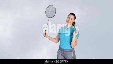 Portrait d'une joueuse de badminton caucasienne tenant une raquette souriant sur fond gris Banque D'Images