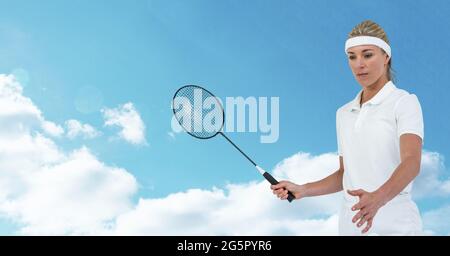 Joueuse de badminton caucasienne tenant une raquette contre les nuages dans le ciel bleu Banque D'Images