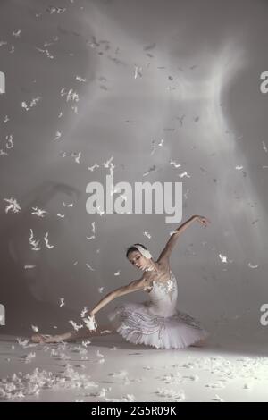 Jeune balerina gracieuse à l'image de cygne blanc dans l'art performance isolée sur fond gris blanc. Banque D'Images