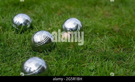 Gros plan de boules de pétanque en acier sur une pelouse verte. Des boules de pétanque en acier chromé reposent sur l'herbe. Jouez dans votre propre jardin. Banque D'Images