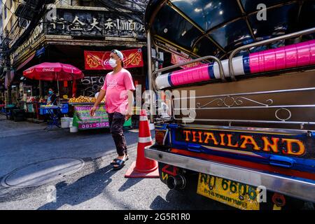 Un homme passe devant un tuk-tuk stationné à Chinatown, Bangkok, Thaïlande Banque D'Images